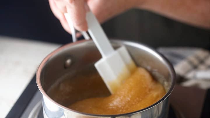 Heating sugar and honey together in a small pot.