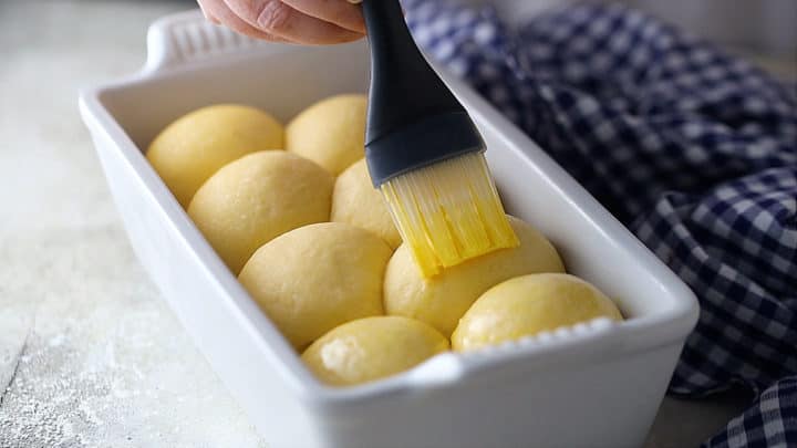 Brushing brioche bread with egg wash before baking.