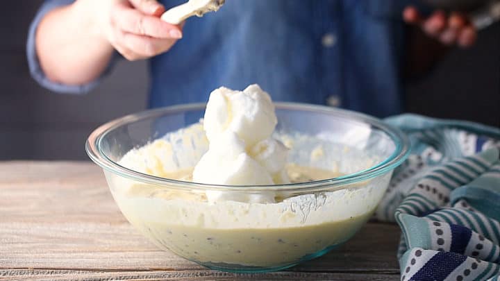 Folding whipped egg whites into pancake batter for extra-fluffy pancakes.