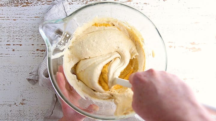 Folding pumpkin mixture in to pumpkin roll cake batter.