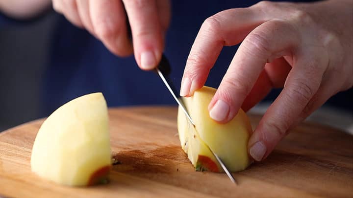 Cutting the core out of a quartered apple.