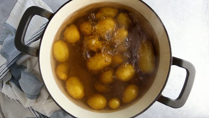 Potatoes simmering in a large pot of salted water.