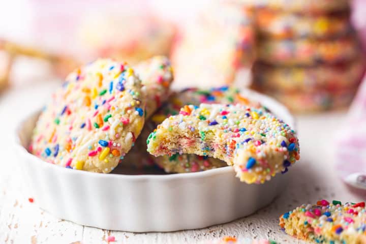Closeup image of funfetti cake cookies, displaying the rainbow sprinkles running all throughout the inside of a cookie.