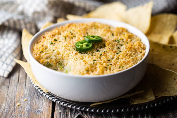 Jalapeno popper dip crock pot transferred to a serving dish and garnished with fresh jalapenos.