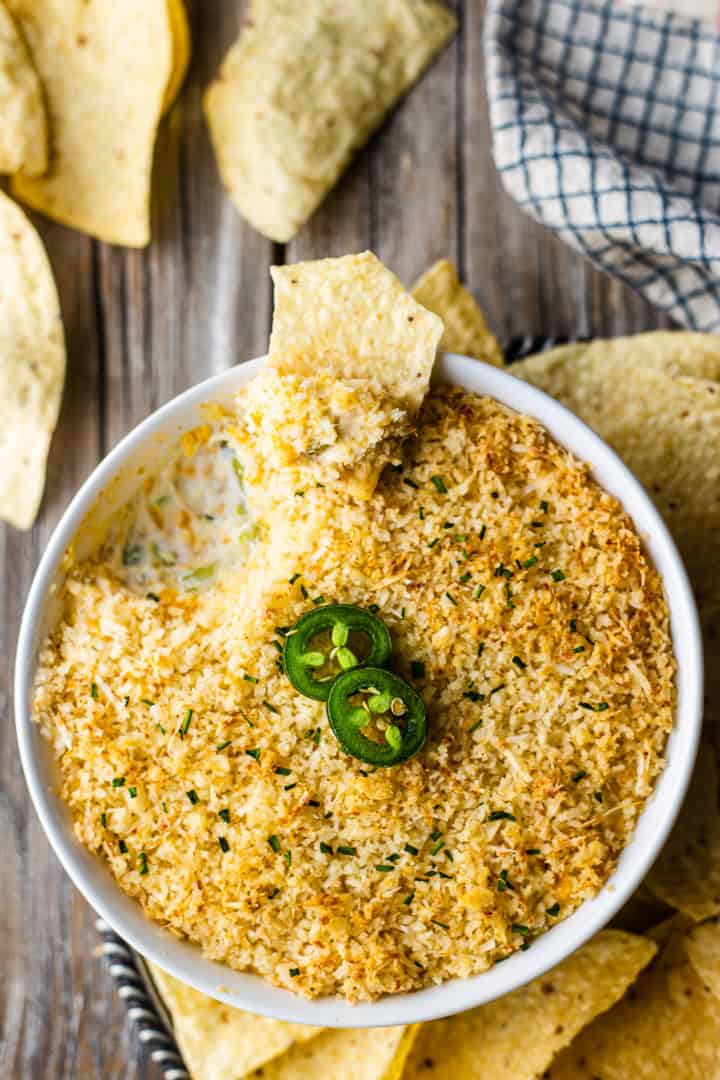 Overhead image of jalapeno popper dip with bacon, surrounded with corn chips.