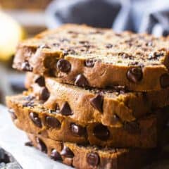chocolate chip banana bread slices stacked on top of one another on white plate