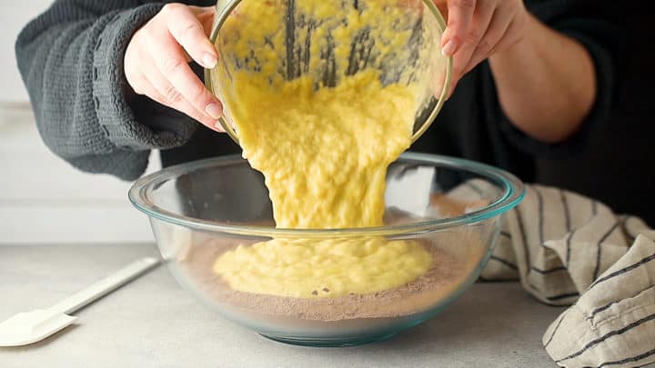 Pouring wet ingredients into dry ingredients.