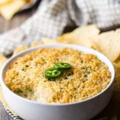 jalapeno popper dip in white bowl topped with two jalapeno slices