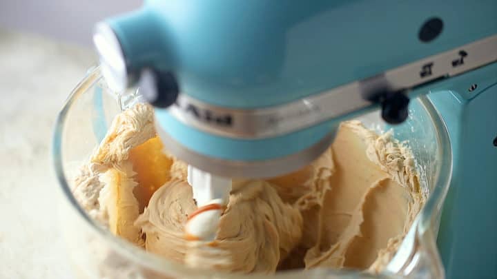 Beating caramel cheesecake ingredients together until smooth.