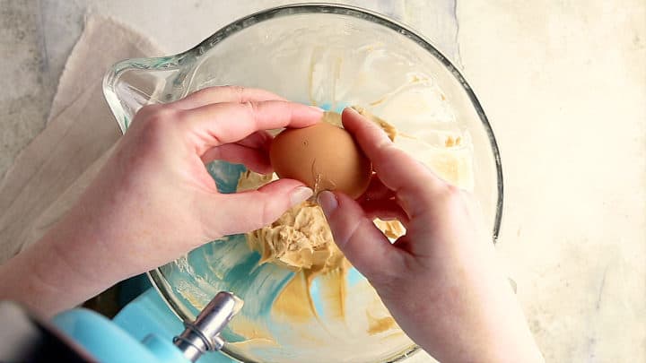 Adding eggs to caramel cheesecake batter.