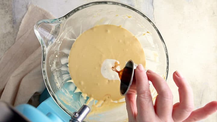 Adding cream and vanilla to caramel cheesecake filling.