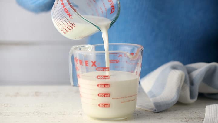 Combining cream and milk in a large liquid measuring cup.