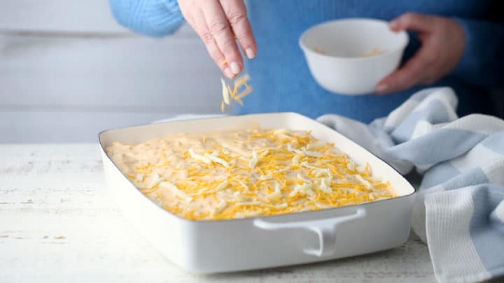 Topping potatoes au gratin with cheese.