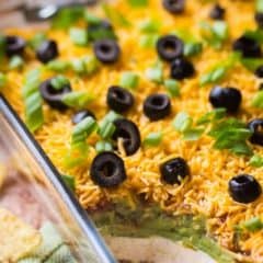 7 layer dip in dish with scoop taken out