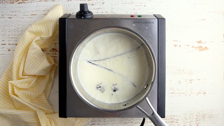 Heating milk, cream, and vanilla together until steaming.