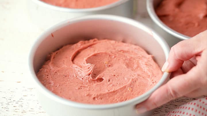 Strawberry cake batter in a round pan.