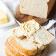 white bread cut in slices and stacked topped with butter