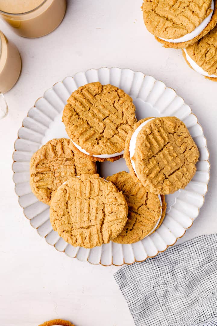 Fluffernutter sandwich cookies on a ruffled white plate with a checked napkin.
