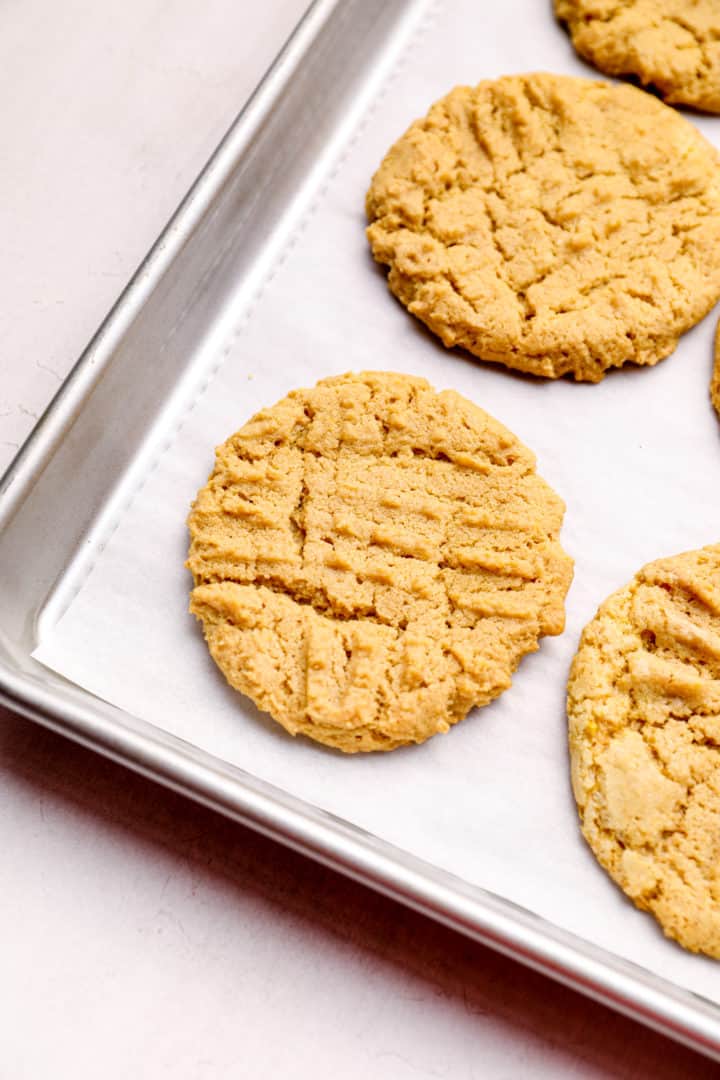 Peanut butter cookies on a tray lined with parchment.