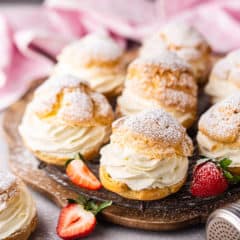 Classic cream puff on a wire rack with strawberries.