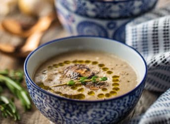 Cream of mushroom soup served in a blue and white bowl.
