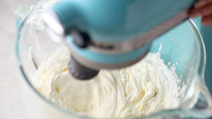 Stiffly whipped cream puff filling in a stand mixer.
