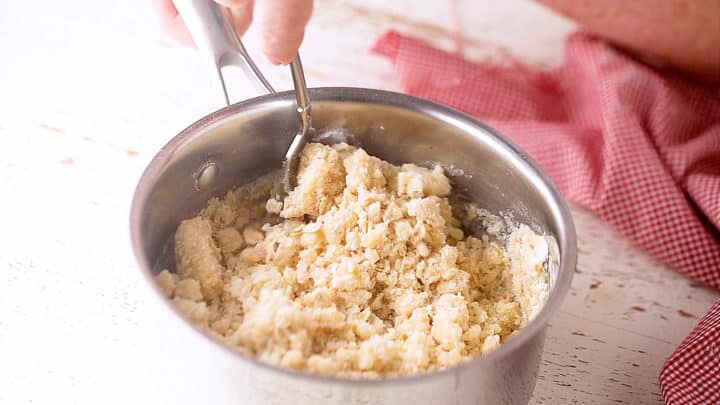 Stirring crumb topping with a fork.