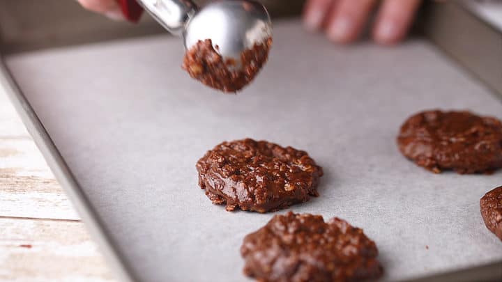 No-bake cookies cooling on a parchment-lined baking sheet.