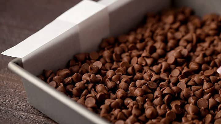 Milk chocolate chips in a square baking pan.