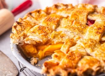 Peach pie recipe prepared and served with a slice cut out, displaying the juicy filling.