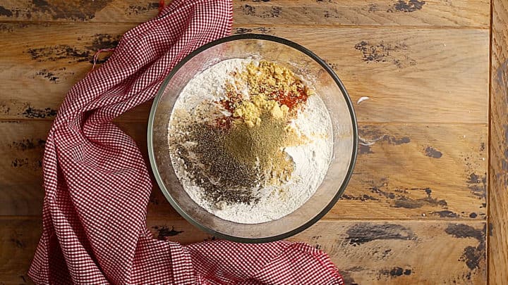 Ingredients for seasoned flour in a large glass bowl.