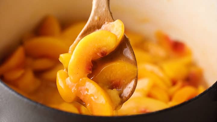 Cooking peach pie filling on the stovetop.