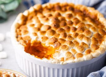 Sweet potato casserole in a souffle dish with a blue cloth.