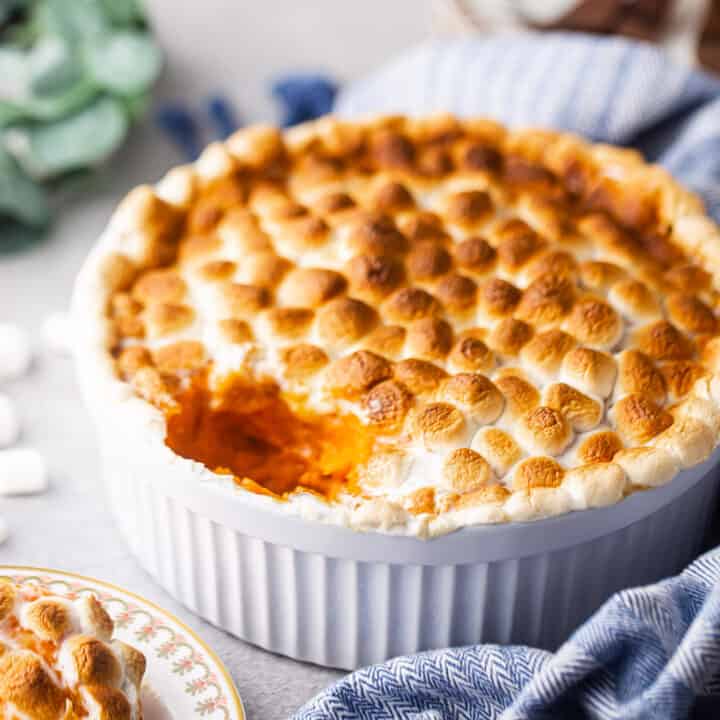 Sweet potato casserole in a souffle dish with a blue cloth.