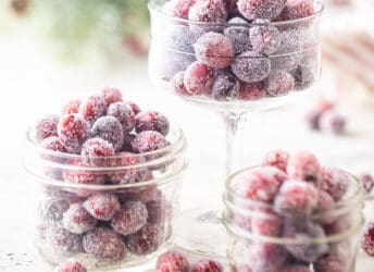 Sugared cranberries displayed in various sized glass bowls.