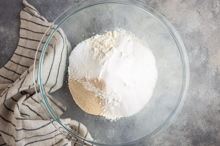 Flour, sugar, yeast, and salt in a glass bowl.