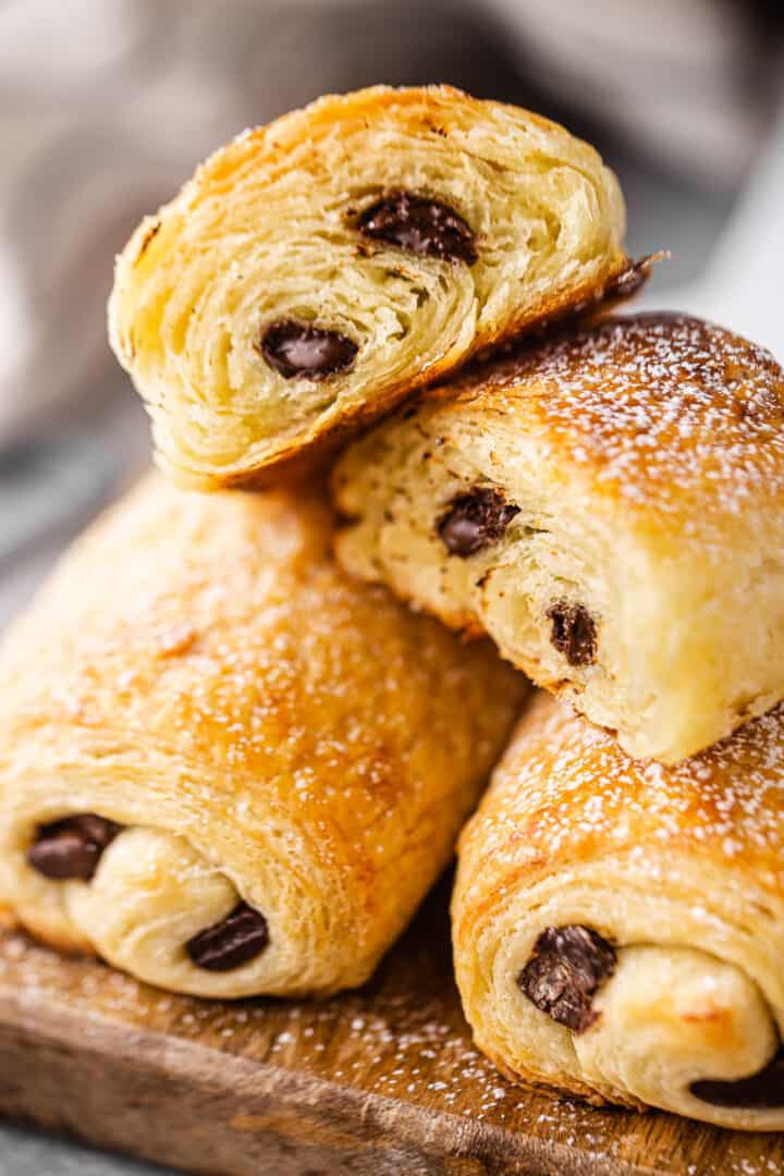 Close up of pain au chocolat recipe, prepared and cut in half, showcasing the many flaky layers of pastry.