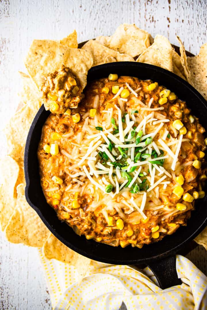 Overhead image of Mexican corn dip in a skillet with corn chips.