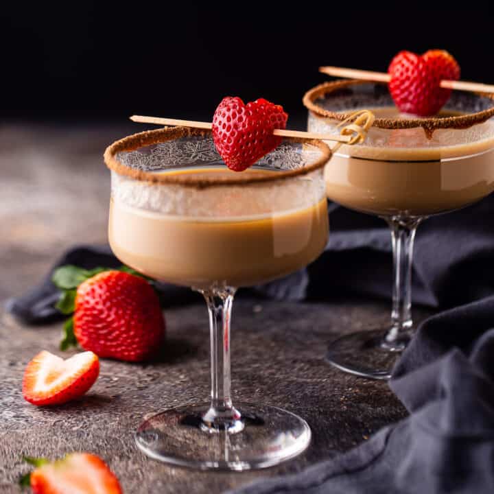 Chocolate martini on a dark background with strawberries.