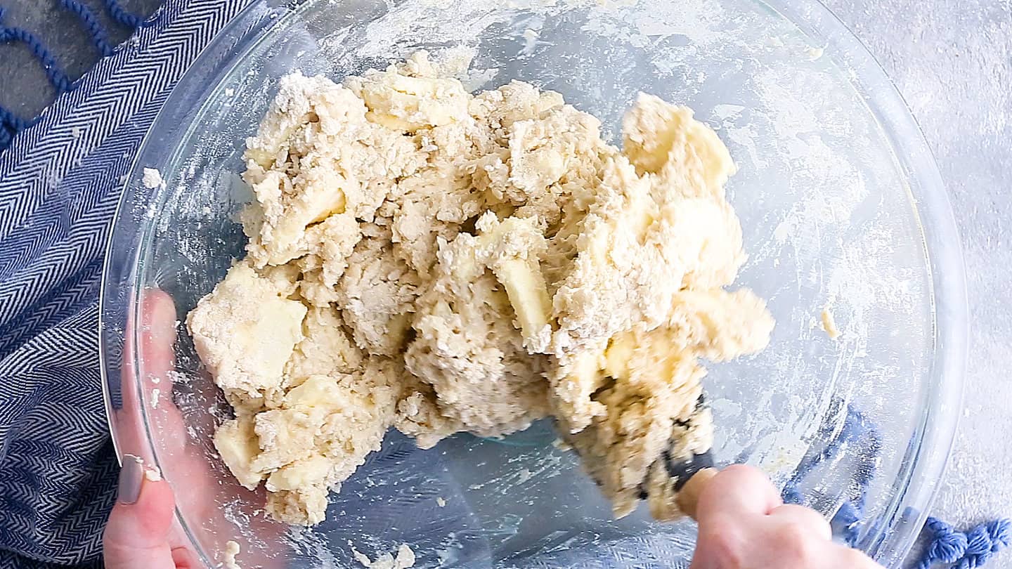 Making homemade croissant dough in a large glass bowl.
