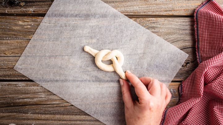 Tying garlic knot dough into a knot.