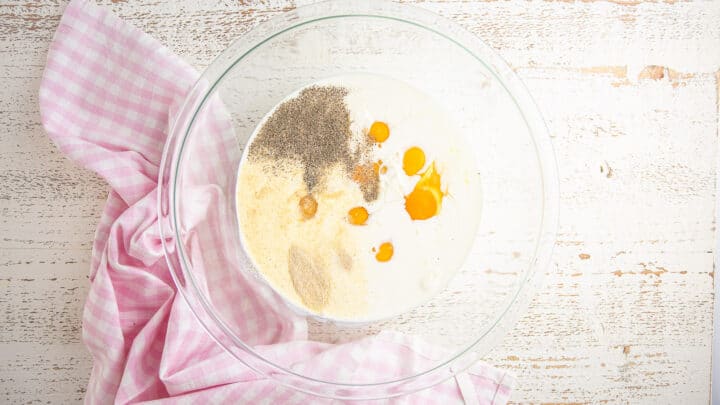 Eggs, milk, cream, and seasonings in a large mixing bowl.
