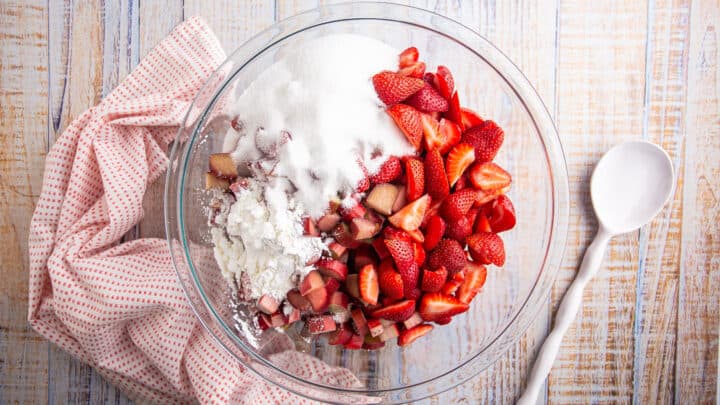 Strawberry rhubarb crisp filling ingredients in a large glass bowl.