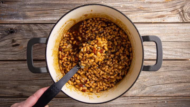 Seasoned baked beans in a large pot before baking.