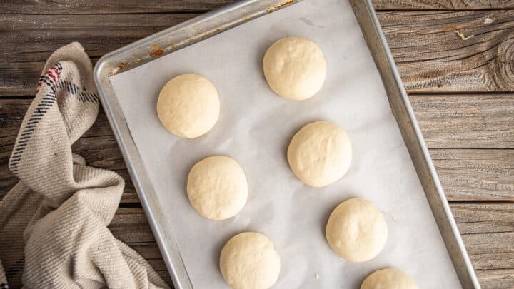 Unbaked, unboiled pretzel buns, shaped and ready to rise.