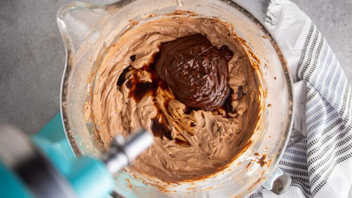 Adding melted chocolate and vanilla to no-bake chocolate cheesecake filling.