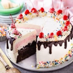 Homemade ice cream cake with layers of cake, fudge, cookies, ice cream, and whipped cream.