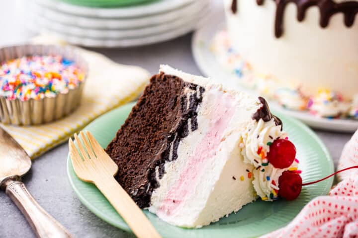How to make ice cream cake, with a thick slice presented on its side on a green plate with a wooden fork.