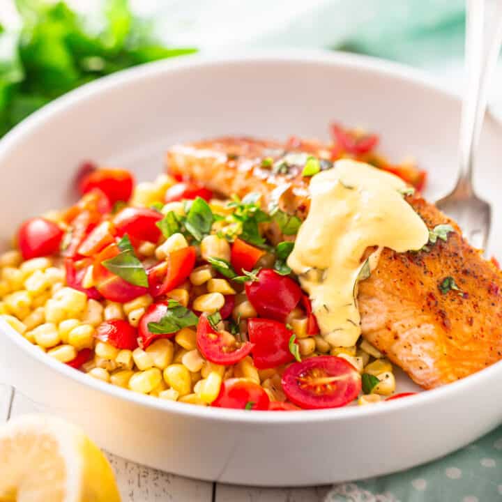 Salmon glaze on roasted salmon filet served over sweet corn and grape tomatoes, with a basil butter sauce.