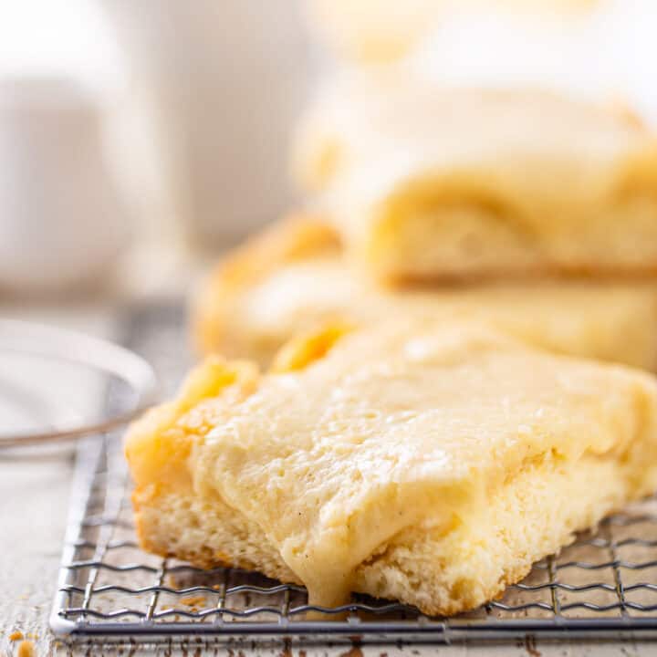 Gooey butter cake on a wire rack with the topping sliding down the side.